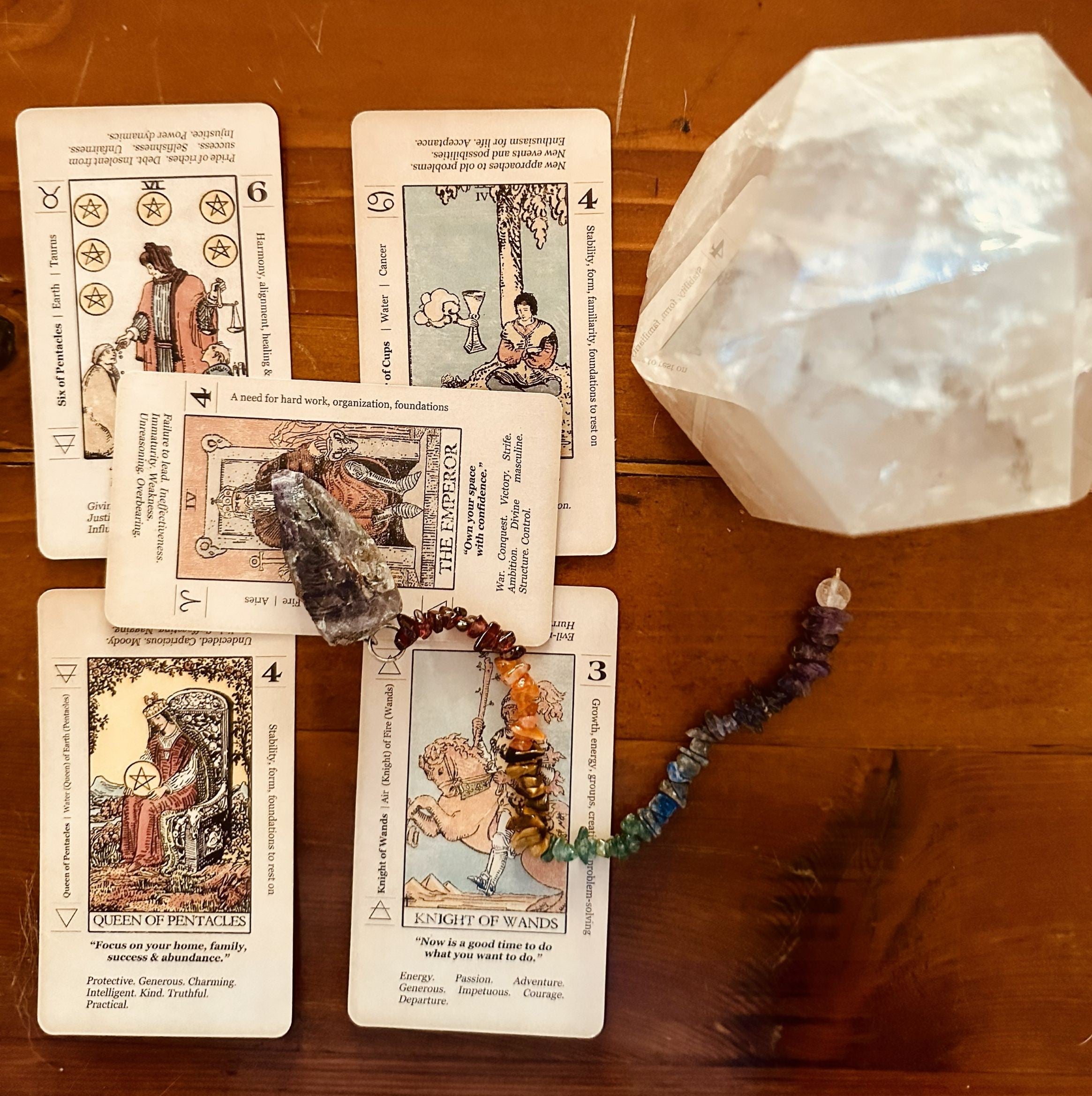 five tarot cards and a pendulum, anchored by a quartz power crystal for expanded spiritual clarity.