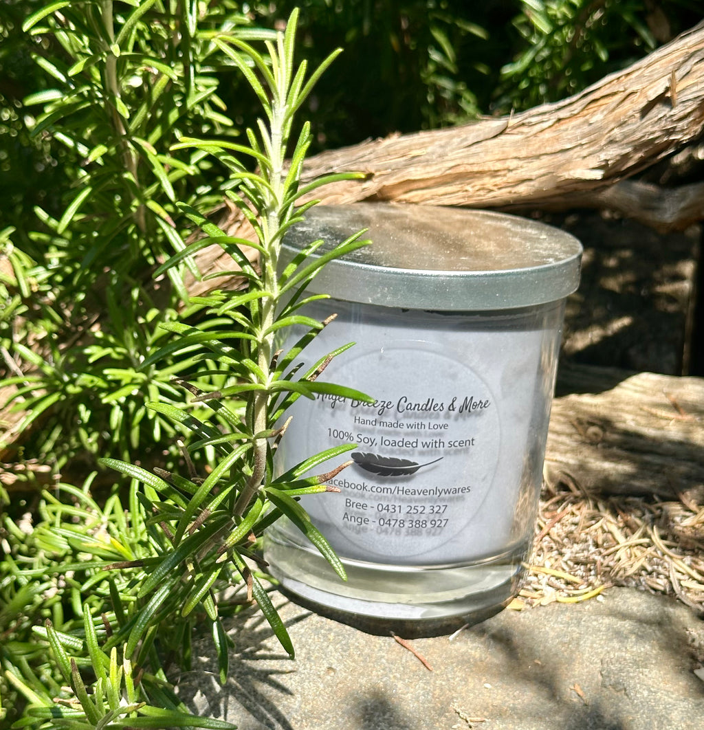 Black Rose and Oud vegan soy candle nestled in rosemary bush