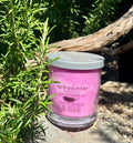 Black Raspberry vegan soy candle nestled in rosemary bush
