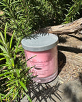 Champagne and Strawberries vegan soy candle nestled in rosemary bush