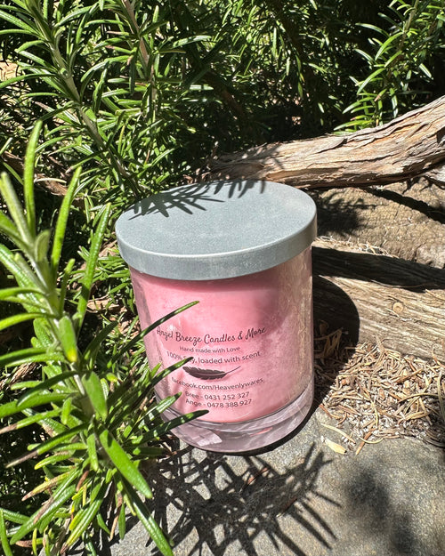 Champagne and Strawberries vegan soy candle nestled in rosemary bush