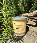 Classic floral (No. 5 inspired) vegan soy candle nestled in rosemary bush