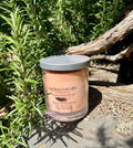 Cheeky Monkey vegan soy candle nestled in rosemary bush