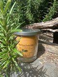Coffee vegan soy candle nestled in rosemary bush