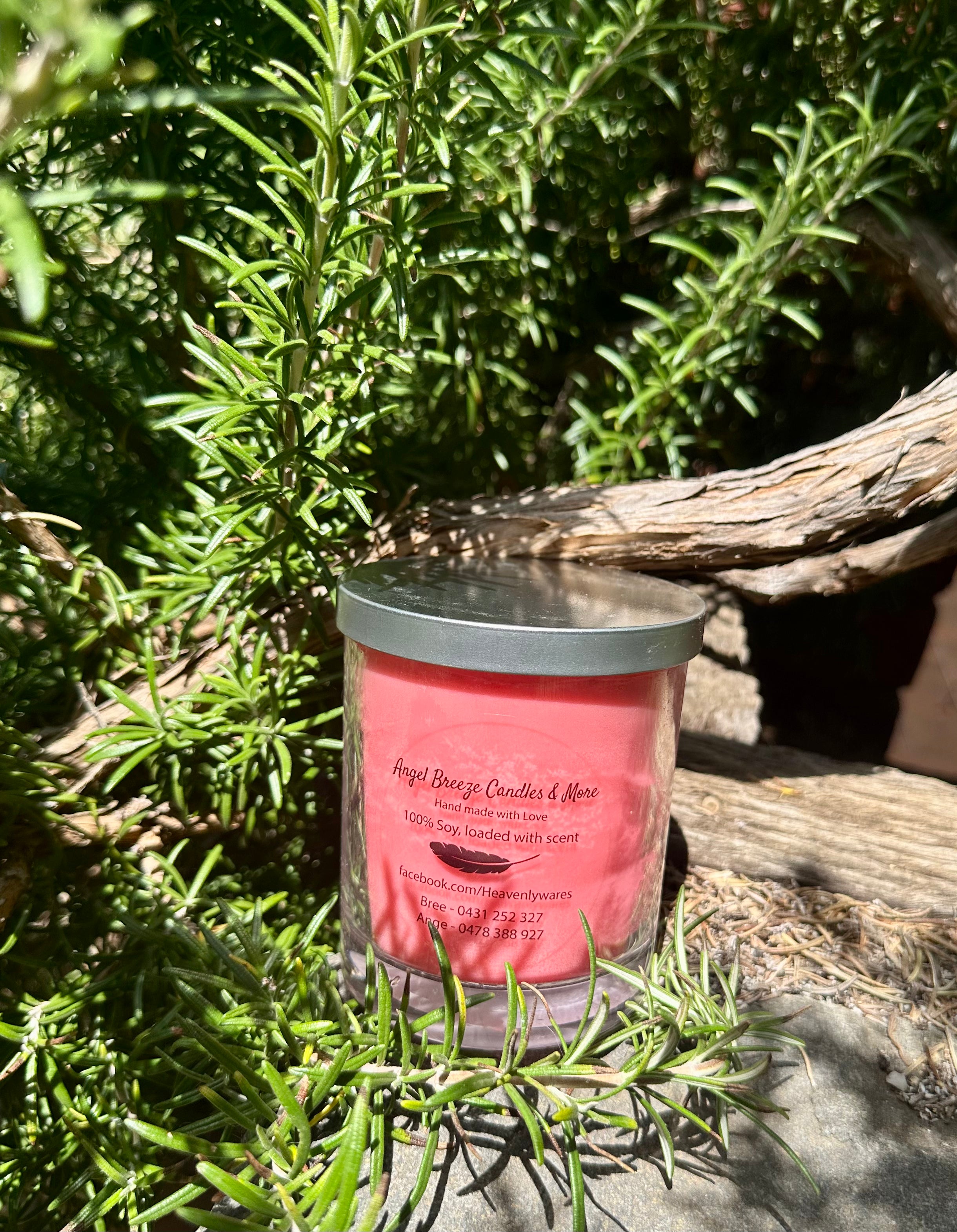 Dragon’s Blood vegan soy candle nestled in rosemary bush