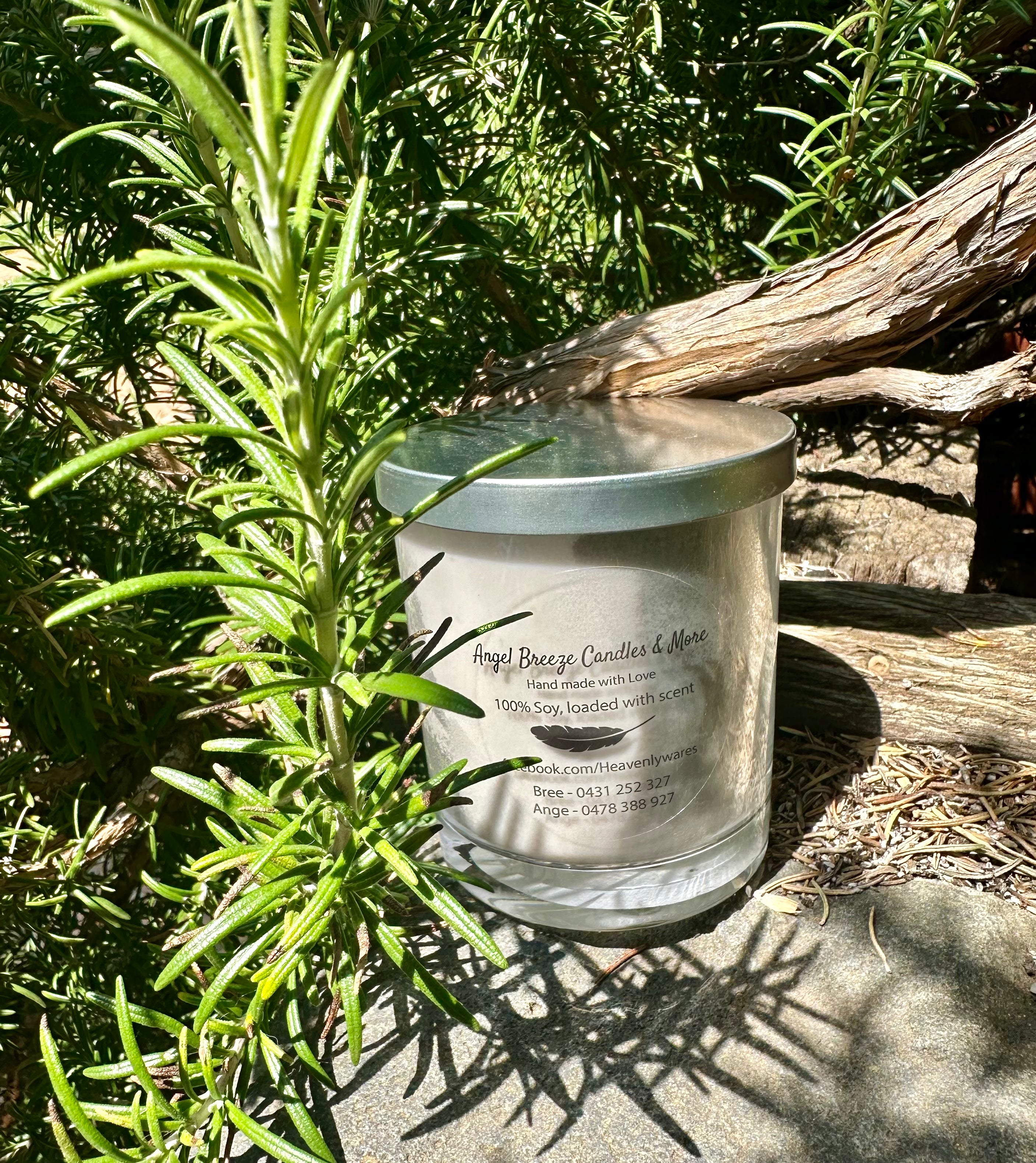 Little Black Dress vegan soy candle nestled in rosemary bush