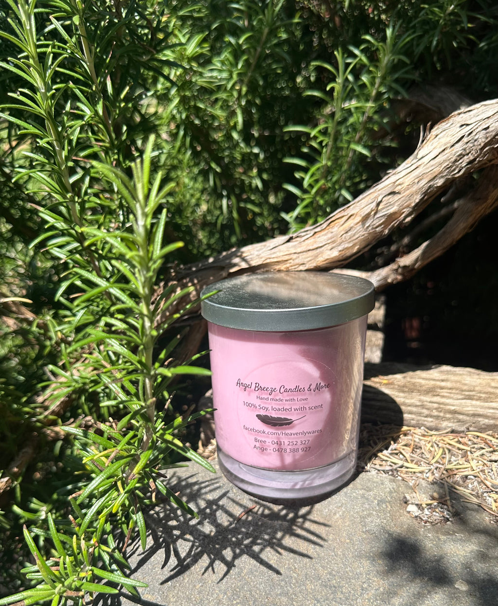 Musk Lollies vegan soy candle nestled in rosemary bush