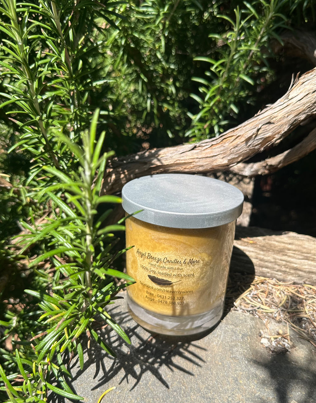 Nag Champa vegan soy candle nestled in rosemary bush