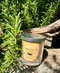 Embers vegan soy candle nestled in rosemary bush