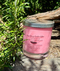 Rose Absolute vegan soy candle nestled in rosemary bush