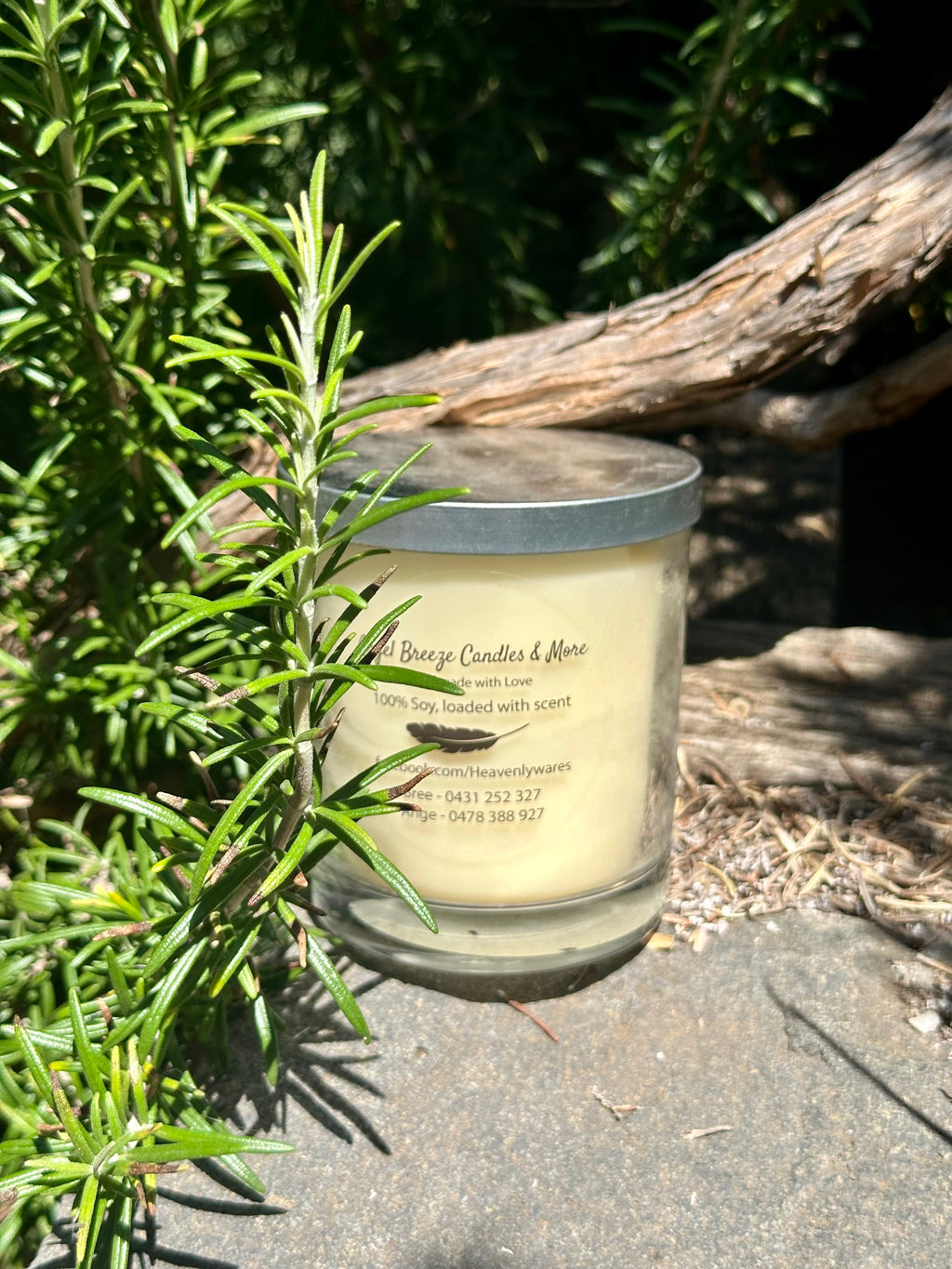Sensual Amber tripled scented vegan soy candle nestled in rosemary bush