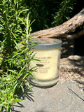 Sensual Amber tripled scented vegan soy candle nestled in rosemary bush
