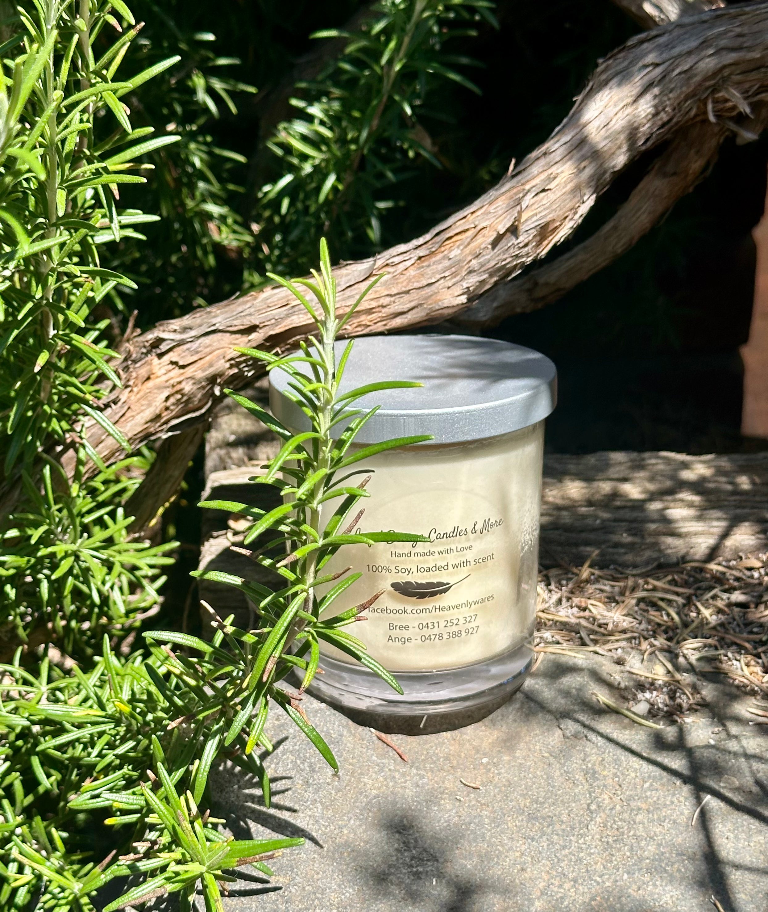 Vanilla Soy Candle in a glass jar with a wooden lid on a stone surface with greenery