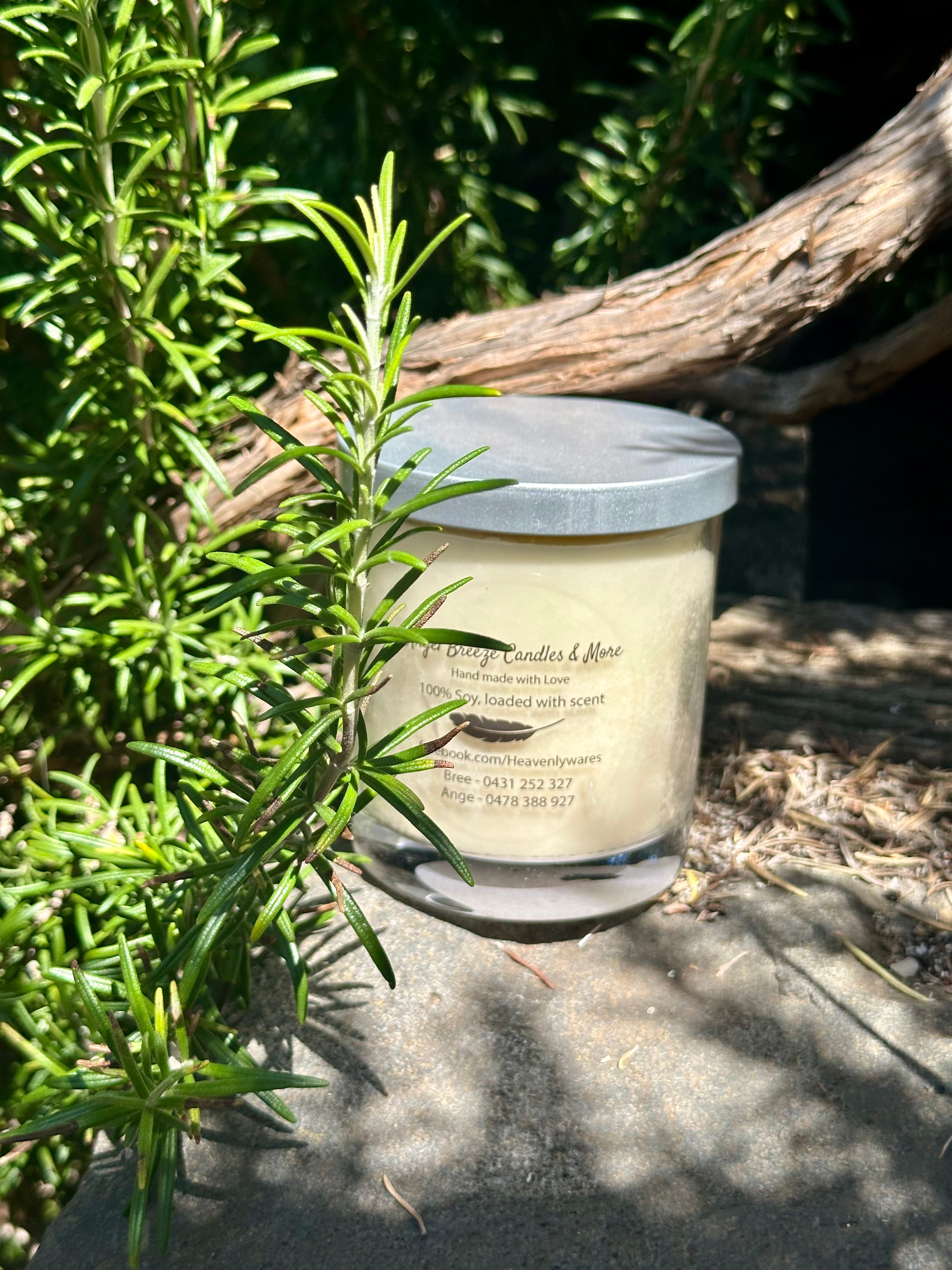 Vanilla Caramel vegan soy candle nestled in rosemary bush